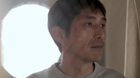 Middle aged asian man looks out the window with sorrow eyes. Stock Footage 224906230