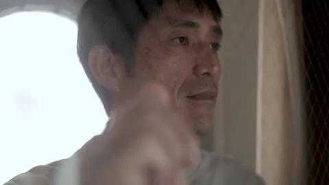 Middle aged asian man looks out the window with sorrow eyes. Stock Footage 224906329