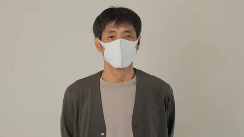 Middle aged asian man with mask on standing still and looks at the camera. Stock Footage 224904077