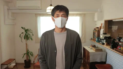 Middle aged asian man with mask on standing still and looks at the camera. Stock Footage 224904702