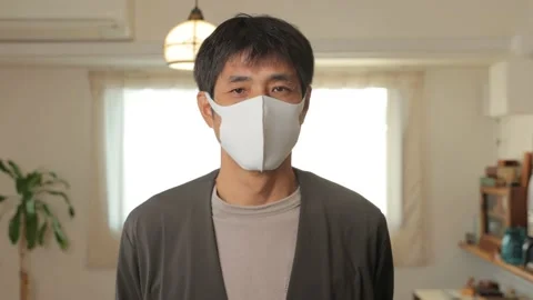 Middle aged asian man with mask on standing still and looks at the camera. Stock Footage 224904742