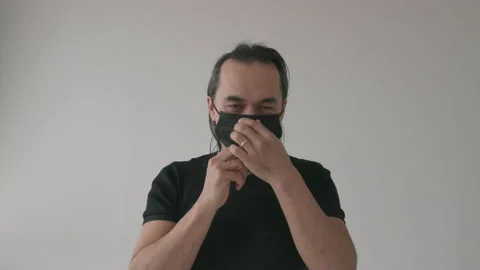 Middle Aged Asian Man Puts on Black Protecting Mask Stock Footage 150673920