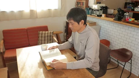 Middle aged asian man reading a book at home. 25P. Stock Footage 224900620
