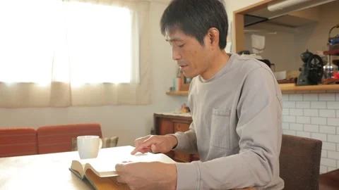 Middle aged asian man reading a book at home. 25P. Stock Footage 224901140