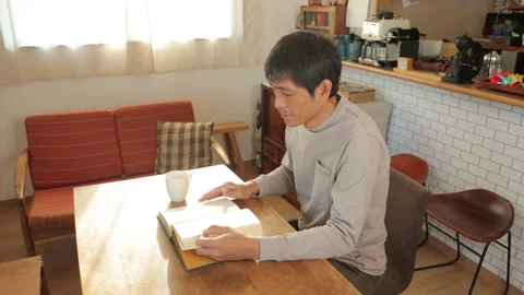 Middle aged asian man reading a book at home. Stock Footage 224905574