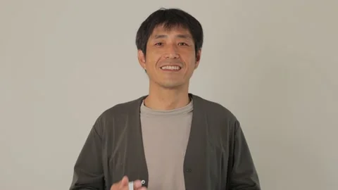 Middle aged asian man takes his mask off and smiles. Relief. 25P. Stock Footage 224899767