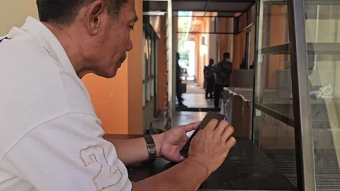 Middle Aged Asian Man Using Smartphone At A Counter Stock Footage 340001145