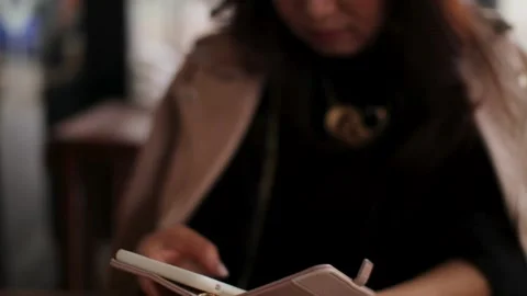 Middle aged asian woman using smartphone at the cafe outside. Serious face. Stock Footage 224449543