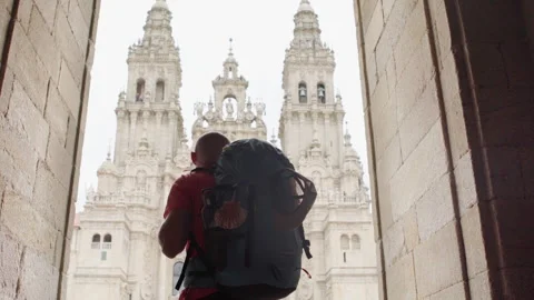 Middle-aged backpacker man pilgrim on Obradoiro square in Santiago de Compostela Video stock 311581820