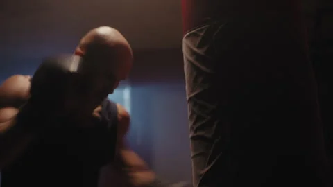 A middle aged bald boxer hitting the bag Vídeo Stock 258249622