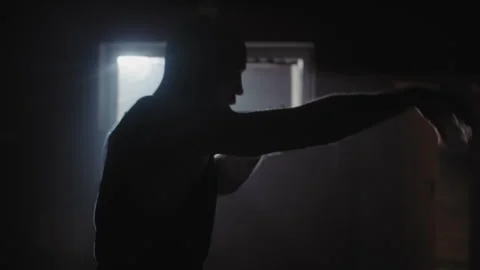 A middle aged bald boxer training in a dark gym Vídeo Stock 258246501