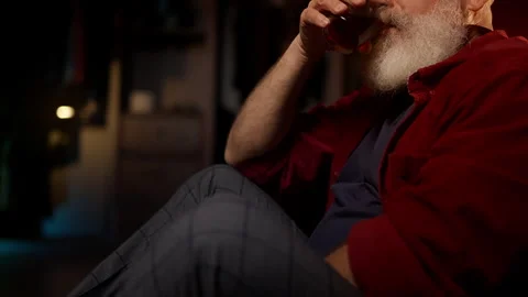 Middle-aged bearded man drinks whiskey on the floor, facing emotional burnout Stock Footage 342520522