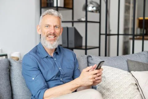Middle aged bearded man using smartphone Stock Photos