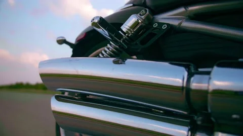Middle-aged biker with beard sits by motorcycle at sunset Stock Footage 154812656