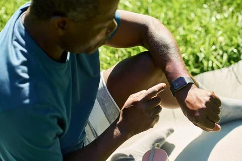 Middle Aged Black Man Checking Heart Rate on Smartwatch Outdoors Foto stock