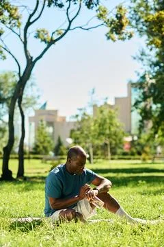 Middle Aged Black Man Checking Smartwatch in Park Foto stock