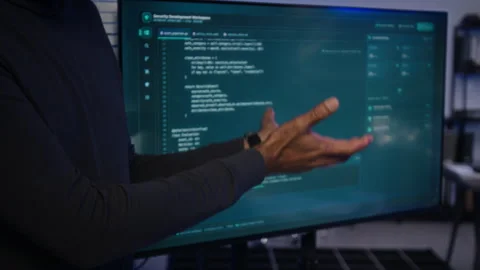 Middle Aged Black Man Explaining Cybersecurity Code on Monitor Stock Footage 347300702