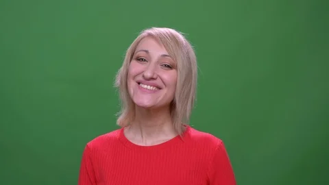 Middle-aged blonde short-haired model smiles prettily into camera isolated on Stock Footage 108677742