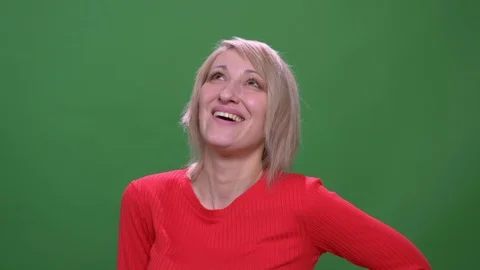 Middle-aged blonde short-haired model laughing joyfully isolated on green Stock Footage 108678097