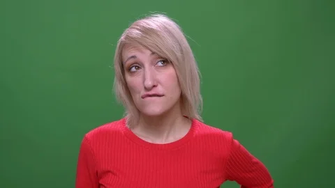 Middle-aged blonde short-haired model thoughtfully biting her lips isolated on Stock Footage 108678775