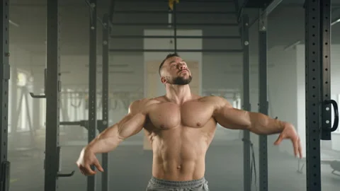 Middle-aged bodybuilder with bare muscular torso posing in front of camera Stock Footage 240340734