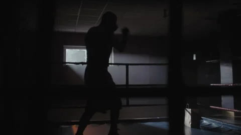 A middle aged boxer training in a dark gym alone Stock-Footage 258242566