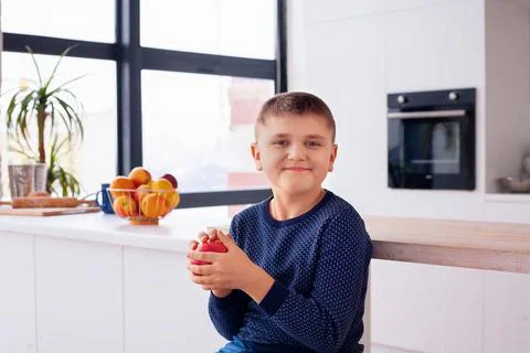 Middle-aged boy with apple in the light room Stock Photos