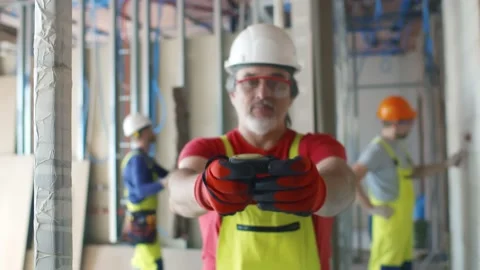 Middle-aged builder using measuring tape on construction site Stock Footage 133635494