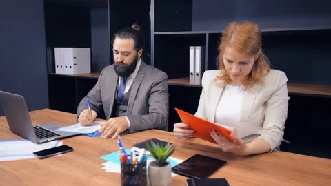 Middle-aged business partners working with documents at workplace Stock Footage 123962879