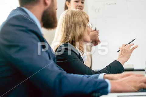 Middle-aged business woman presenting her opinion during a meeting Stock Photos