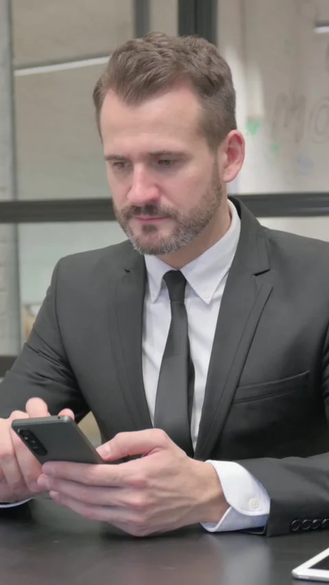 Middle Aged Businessman Browsing Internet on Phone, vertical video 스톡 동영상 324793586