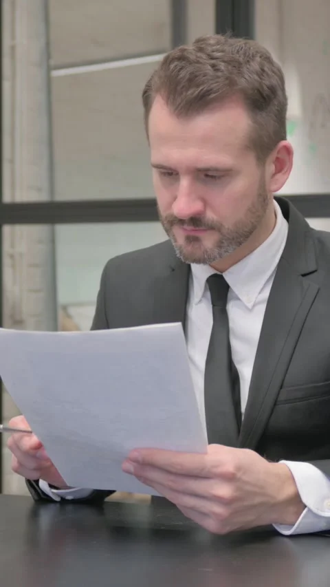 Middle Aged Businessman Celebrating while Reading Documents, vertical video Stock Footage 324795145