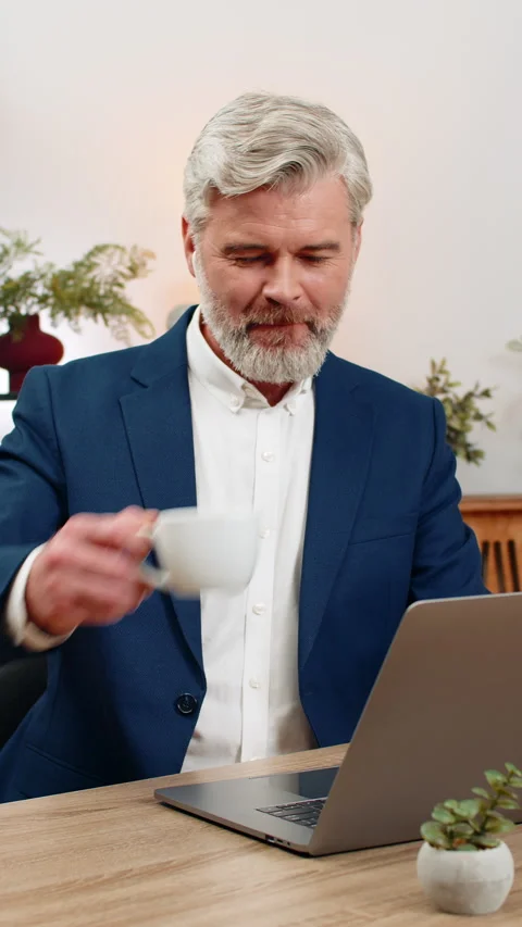 Middle-aged businessman coding on laptop with earphones listens to music focused Stock Footage 348056915