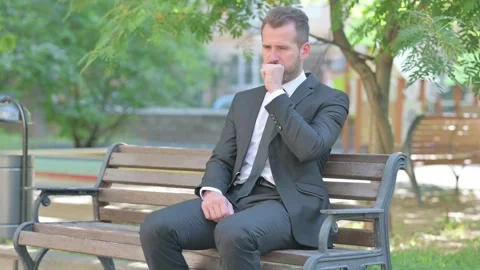 Middle Aged Businessman Coughing while Sitting Outdoor on Bench Stock Footage 287922660