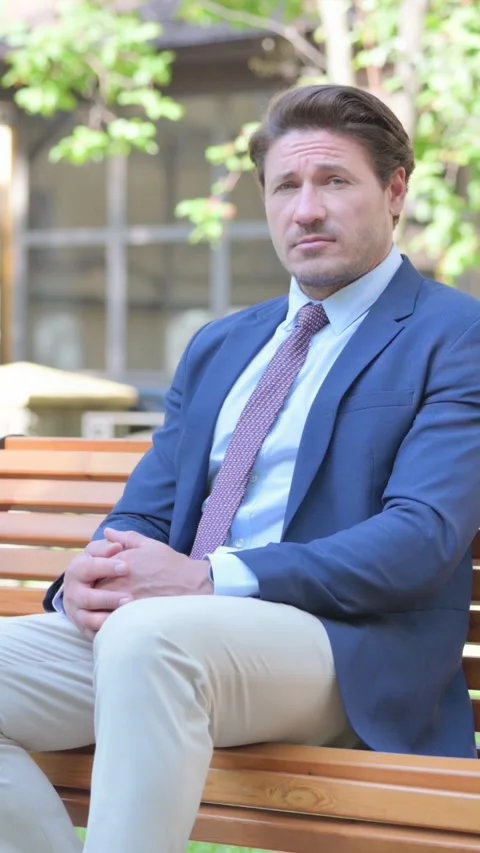 Middle Aged Businessman Looking at Camera while Sititng Outdoor, vertical Stock Footage 321121355