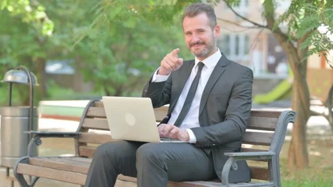 Middle Aged Businessman Pointing at Camera while Using Laptop Video stock 287926604