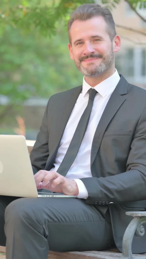 Middle Aged Businessman Pointing at Camera while Using Laptop, Vertical Video Stock Footage 319049992