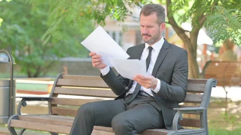 Middle Aged Businessman Shocked while Reading Documents Outdoor Stock Footage 287923882