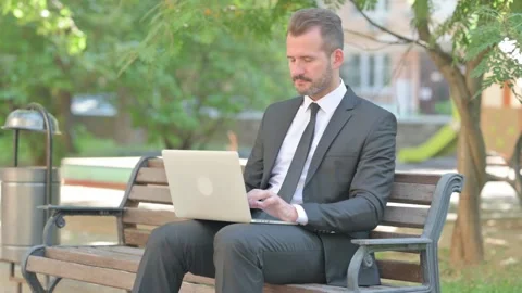Middle Aged Businessman Smiling at Camera while Using Laptop Outdoor Video stock 287925796