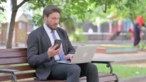 Middle Aged Businessman Using Smartphone and Laptop Outdoor 스톡 동영상 313586290