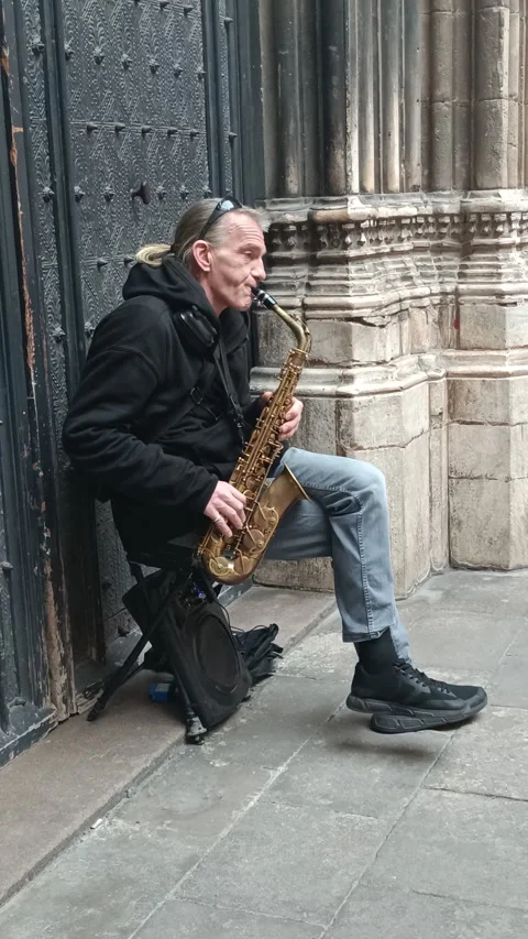 Middle-aged busker playing jazz music on a saxophone Stock Footage 328525740
