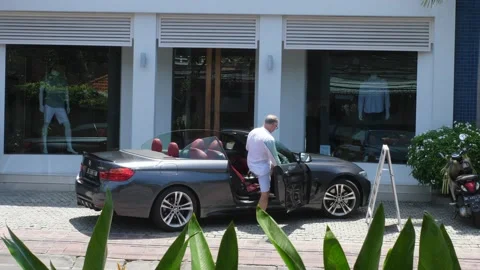 Middle aged Caucasian Man getting into his convertible car. Bali- Indonesia-2021 Stock Footage 150435587