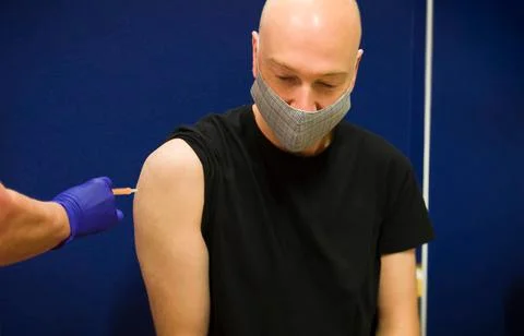 Middle aged Caucasian man getting Covid 19 vaccine, UK Stock Photos