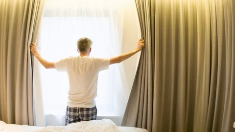 Middle aged Caucasian man opening curtains in a hotel room Video stock 79178218