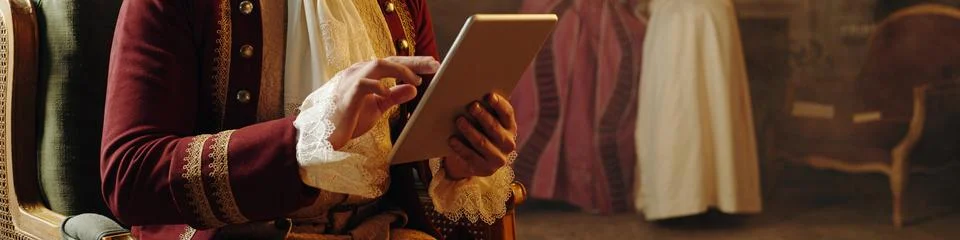 Middle Aged Caucasian Man Using Digital Tablet in Baroque Renaissance Setting Foto stock