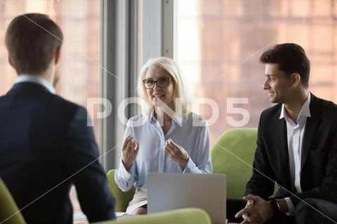 Middle aged company owner negotiating with business partners Stock Photos