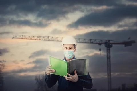 Middle aged contractor or architect holding a document folder, wearing protec Stock Photos