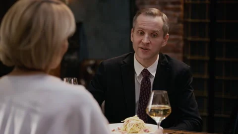Middle-Aged Couple Clinking Wine Glasses at Table in Fine Dining Restaurant Stock Footage 333396724