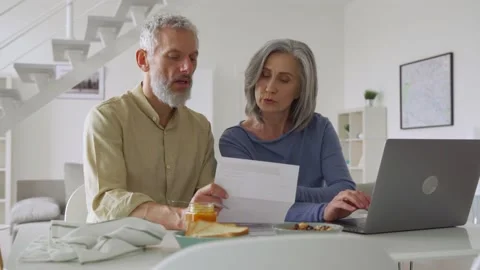 Middle aged couple couple paying financial bills using laptop at home. Stock Footage 164029148