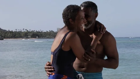 Middle-aged couple embracing and laughing on a beach. 스톡 동영상 88367495